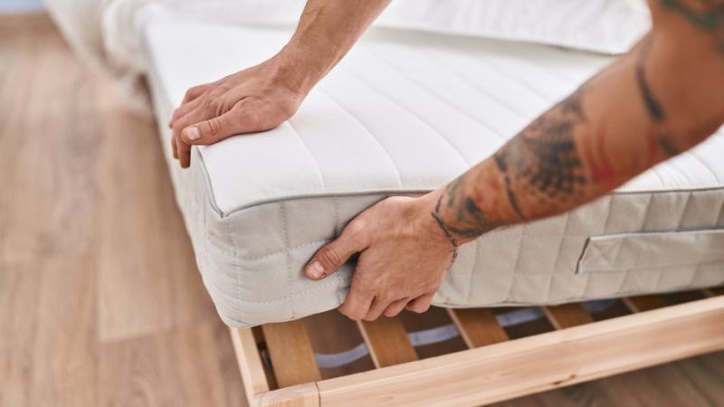 Мужчина тестирует качество матраса, чтобы тот не навредил позвоночнику